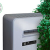 Monoblock warmtepomp met groene struik eromheen