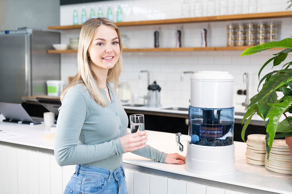 Jongedame staand in keuken met Aqualine waterfilter op aanrecht