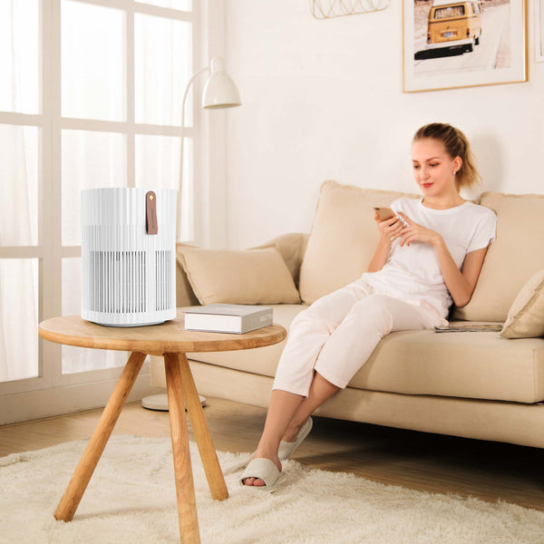 Dame in woonkamerr met AirExchange 150‑T, fluisterstille luchtreiniger, voor schone lucht en betere slaap, wit