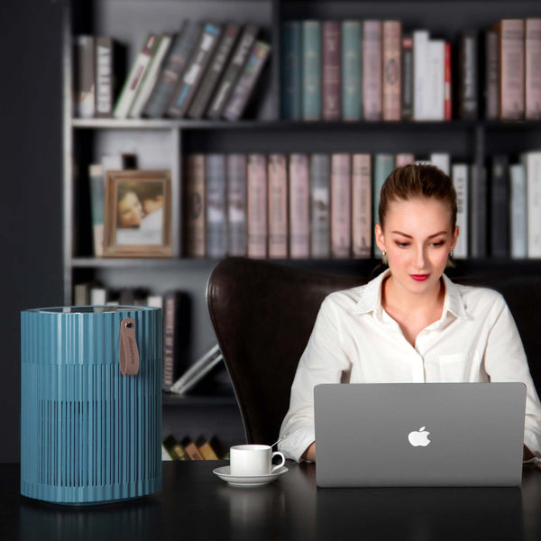 Dame aan bureau met AirExchange 150‑T, fluisterstille luchtreiniger, voor schone lucht en betere slaap, blauw