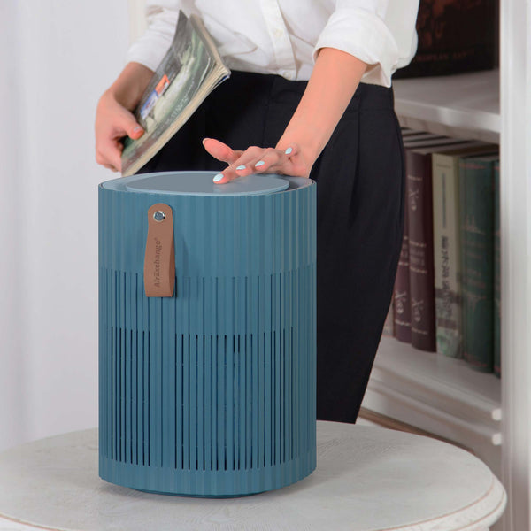 Dame met hand op de AirExchange 150‑T, fluisterstille luchtreiniger, voor schone lucht en betere slaap, blauw